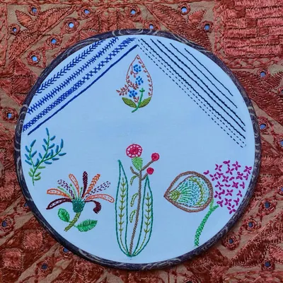 The satisfaction of finishing a project is immense. This hoop art piece, with its mix of stitches and floral motifs, is truly captivating and ready to hang on a wall.