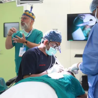 Demonstrating FUE extraction techniques during a live surgical workshop at the FUEASIA ASEAN regional event in Bangkok, Thailand.