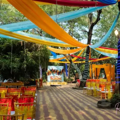 An overview of our carnival-themed decor for an outdoor event, featuring a canopy of bright, colorful drapes and vibrant seating arrangements.
