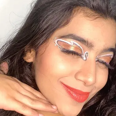 A simple but stunning graphic eyeliner look using white liner to create abstract shapes above the crease. It's a great way to add an artistic touch to your makeup.