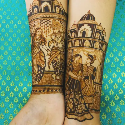 I love creating narrative designs. On the left arm, I've depicted the divine love of Radha and Krishna, and on the right, a portrait of the wedding couple, all framed by palace architecture.