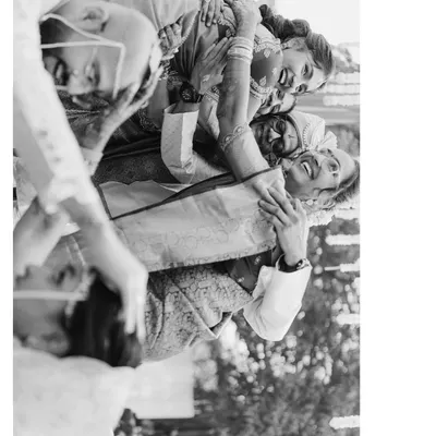 A candid, joyful moment from Mohita and Tejas's wedding. The black and white format emphasizes the raw emotion and laughter being shared among family and friends.
