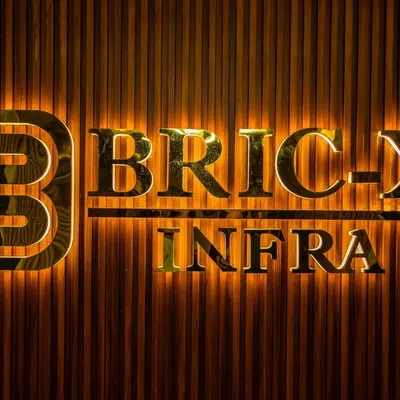 A close-up shot of a backlit company logo, highlighting the modern branding and textured wall of a corporate office.