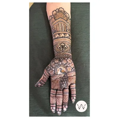 A beautiful and intricate design for the mother of the bride, featuring elephants, lotuses, and a peacock.