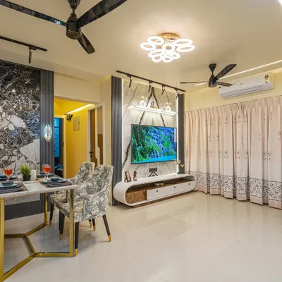 This view shows how the living and dining areas are connected. I used consistent design elements like the marble-finish wall panels and gold accents to create a unified, high-end look throughout the open-plan space.