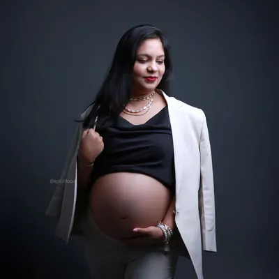 A powerful "boss-mama" look, pairing a white blazer with a bare bump for a confident and modern maternity statement.