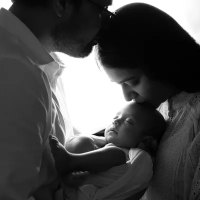 A beautiful and artistic black and white silhouette of new parents holding their baby. This is a classic pose we love to create during newborn family sessions.