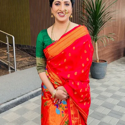 A full-length portrait of actress Madhurani Prabhulkar in a vibrant red saree.