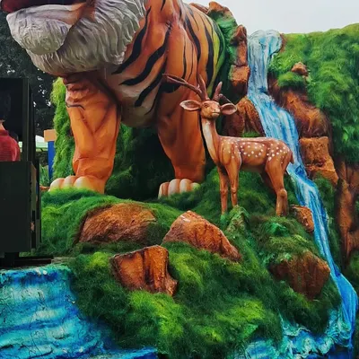 I love bringing the power of nature to life. This large-scale sculpture shows a tiger and a deer by a waterfall, all carved and painted to look as realistic as possible. It's a great example of how I create dynamic wildlife scenes for exhibitions and events.