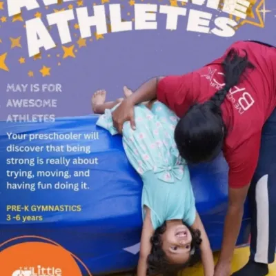 For our preschool "Awesome Athletes," being strong is all about trying, moving, and having fun. An instructor helps a happy child with a supported forward roll, showing our hands-on approach.