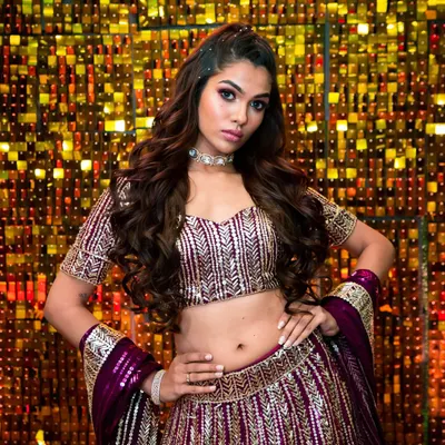 A flawless mix of elegance and glamour. This look, with its bold eye makeup and radiant skin, is perfect for a Sangeet or reception, set against a glittering backdrop.