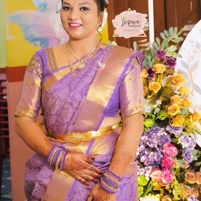 A gorgeous bride-to-be for her engagement ceremony. She looks radiant in her purple Kanjeevaram saree, with makeup that is both traditional and glamorous.