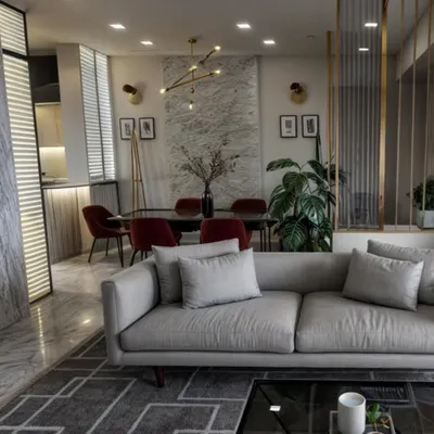 A view of a lavish living room we designed, showcasing a harmonious blend of modern furniture, luxurious textures, and elegant gold accents. The open-plan layout connects seamlessly to the dining area, creating an ideal space for entertaining.