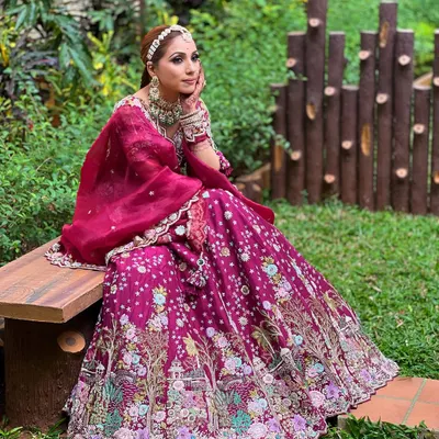 This stunning magenta lehenga is paired with one of the beautiful emerald and polki sets available for rent.
