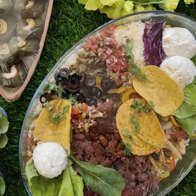 Our layered burrito bowl is a complete meal in one dish. It's packed with rice, refried beans, salsa, olives, and cheese, then topped with crunchy taco shells for a mix of textures and flavors.