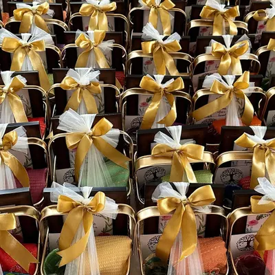 Thoughtful housewarming return favours in elegant golden metal baskets. Each basket contains a blouse piece, glass bangles, a photo frame, and other traditional items to thank guests for their blessings.