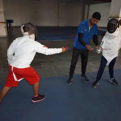 I am providing a student with direct, hands-on correction of his blade work. This personalized guidance is crucial for developing precise technique and is a cornerstone of our coaching philosophy.