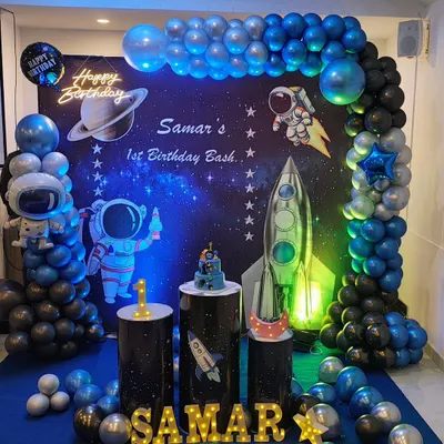 Here's another take on the popular space theme for a first birthday bash. This one features a custom printed flex backdrop, a neon 'Happy Birthday' sign, and character cutouts of astronauts and rockets.