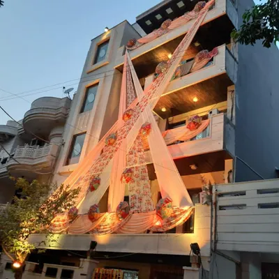A full building facade decoration for a day event. I use elegant peach drapes and floral baskets to create a festive look that makes the entire house feel like part of the celebration.