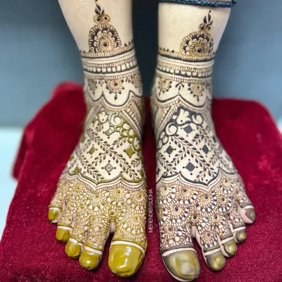 A stunning full-coverage bridal foot mehendi. This design features intricate net patterns, leafy vines, and delicate bands around the ankles, ensuring your feet look beautiful from every angle.
