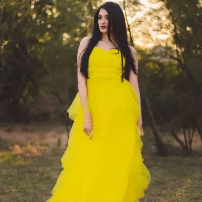 This vibrant yellow tiered tulle gown is a fantastic choice for a portfolio shoot. Its bright color and playful layers stand out beautifully in natural, golden-hour lighting.