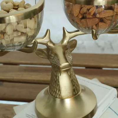 A close-up of our majestic golden reindeer bowl stand. The intricate texture of the reindeer's head and the elegant glass bowls make this a truly enchanting piece for serving snacks.