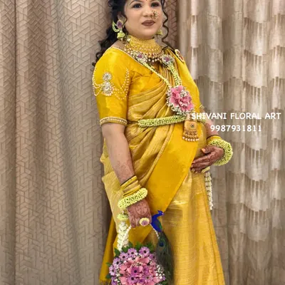 This beautiful mom-to-be is glowing at her baby shower in a custom floral jewellery set. I designed her look with a floral waist belt (kamarbandh), armlets, and a unique floral purse with a peacock feather detail.