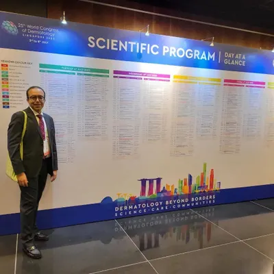 At the 25th World Congress of Dermatology in Singapore, standing before the extensive scientific program. Attending these events is crucial for learning about global advancements and bringing the best practices back to my patients in Delhi.