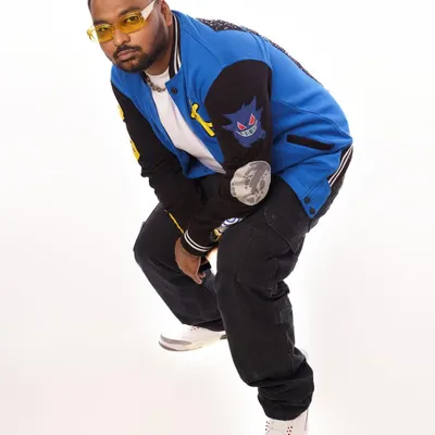 A fresh press shot showcasing my style. The custom varsity jacket and yellow-tinted glasses are part of my signature look.