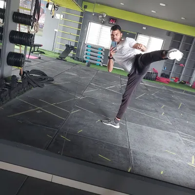 A dynamic side kick captured in the mirror. This is one of the fundamental moves we practice in cardio kickboxing, focusing on power, balance, and control for a full-body workout.