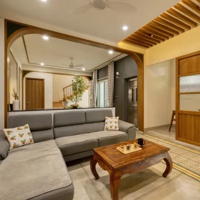 A view of the Villa 17 living room, where a custom L-shaped sofa is framed by a wooden archway, creating an inviting and connected space.