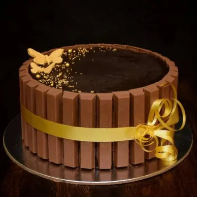 A classic and much-loved design. This chocolate truffle cake is wrapped with KitKat bars and tied with a beautiful gold ribbon. A simple gold butterfly adds a touch of elegance.