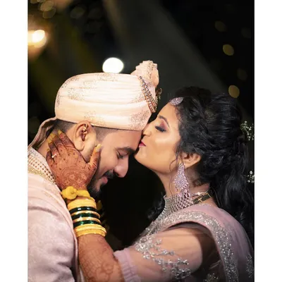 A beautiful candid moment from a wedding reception. A gentle kiss on the forehead filled with love and emotion.