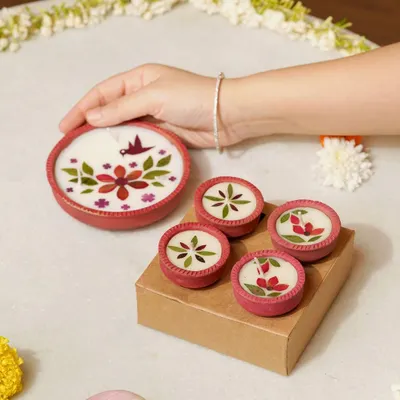 A hand gently arranges beautifully handcrafted diyas made with dried flowers. This shot highlights the artistic detail and traditional charm of the product, perfect for Diwali gifting and decor.