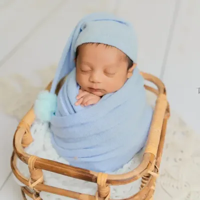 Snuggled up and dreaming in soft blue hues. This classic basket pose with a sleepy hat is a timeless way to capture the sweetness of a newborn boy.