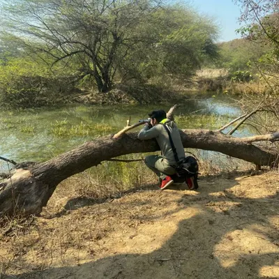Here I am in my natural habitat, using a fallen log as a natural tripod to get a stable shot. This is what a typical day of shooting looks like for me, finding the right angle and waiting for the perfect moment.