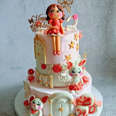 This two-tiered cake was a dream to make for a second birthday, featuring a hand-modelled fondant doll, adorable bunnies, and delicate butterfly accents.