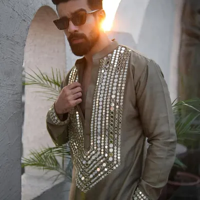 A standout piece for a Mehndi or Haldi ceremony. This olive green kurta is heavily embellished with a mosaic of real mirrors on the neckline and cuffs, designed to catch the light and everyone's attention.