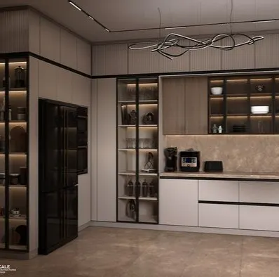 A luxury kitchen design featuring glass-front display cabinets with internal lighting, handleless drawers, and a built-in refrigerator. The combination of off-white, wood textures, and a modern sculptural light fixture creates a highly sophisticated and functional space.