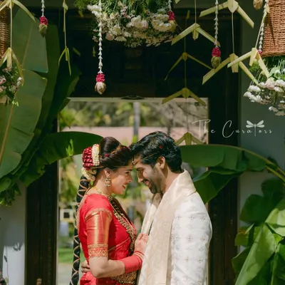 A moment of quiet connection between the couple, framed by a traditionally decorated doorway. We used banana leaves and hanging floral baskets to honor South Indian wedding customs.