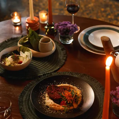 For Valentine's Day, we create an atmosphere of pure romance. This table, set for two with candlelight and a glass of red wine, showcases our special set menu designed for an unforgettable evening.