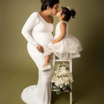 A mother's love is a bond like no other. This tender moment, a sweet kiss from her firstborn, perfectly captures the love that is about to expand to welcome a new family member.