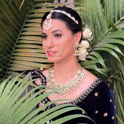 An editorial-style shoot featuring a regal look with a dark velvet blouse, kundan jewelry, and a classic floral bun.