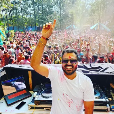 The view from my console at a massive Holi festival in Whitefield. This image perfectly captures the scale and vibrant energy of the event, with a huge, colorful crowd partying under the sun.