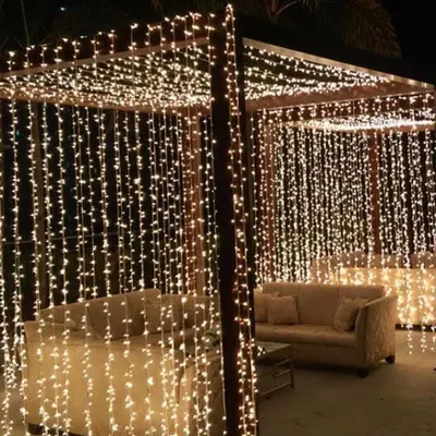 Fairy lights are my secret weapon for creating a magical ambiance. Here, I've draped the entire pergola in curtains of warm fairy lights, turning the seating area into a cozy, starlit grotto.