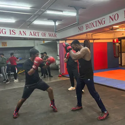 The intensity of our men's batch is on full display as two boxers engage in a controlled padwork drill. This is where technique is tested and refined under pressure, simulating real ring conditions.