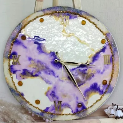 A closeup of a stunning resin art clock, showcasing the beautiful swirls of purple and gold. Our students learn to master these fluid techniques to create functional art.