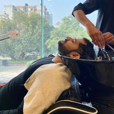We also offer pampering sessions for men. This client is enjoying a relaxing hair wash and scalp massage as part of our men's grooming services.