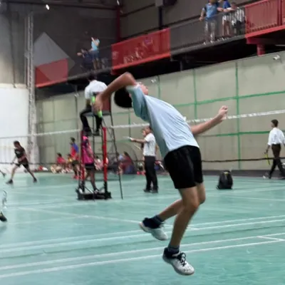 This is the result of dedicated training. A player executes a powerful jump smash, a technique we perfect through drills focusing on timing, footwork, and explosive strength.