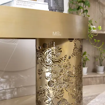 A detail shot of the Ferrosa Console's base. This view highlights the intricate, laser-cut Jaali-inspired pattern in a brushed antique gold finish, showcasing how we reimagine traditional architectural elements in a contemporary form.